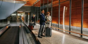 Professional driver waiting at LAX arrivals terminal with a name sign