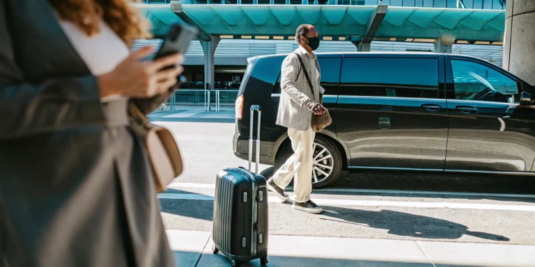 Professional private shuttle van at LAX airport terminal with driver assisting passengers