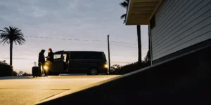 Private shuttle van picking up a traveler before dawn in Los Angeles for an early LAX flight