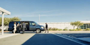 Private shuttle van at LAX terminal with group travelers and luggage