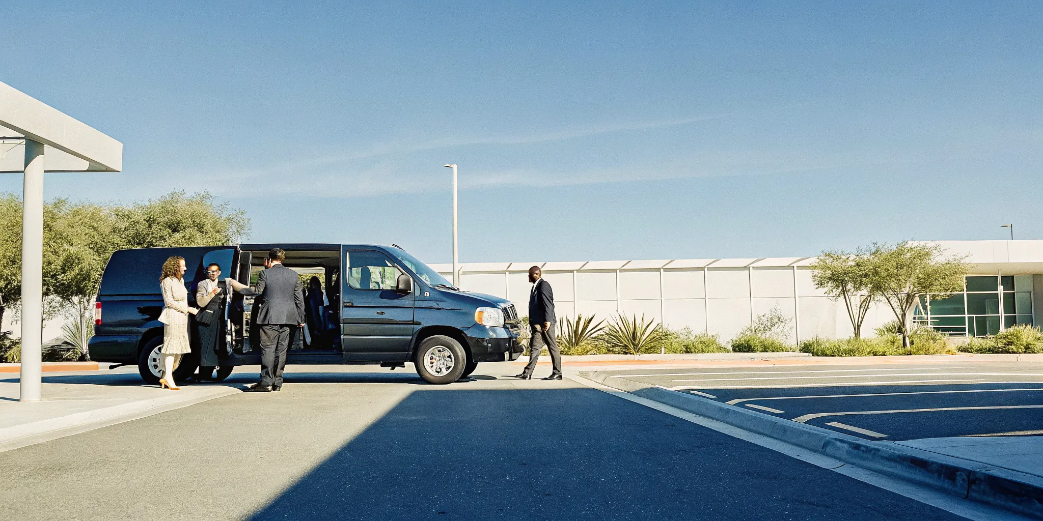 Private shuttle van at LAX terminal with group travelers and luggage